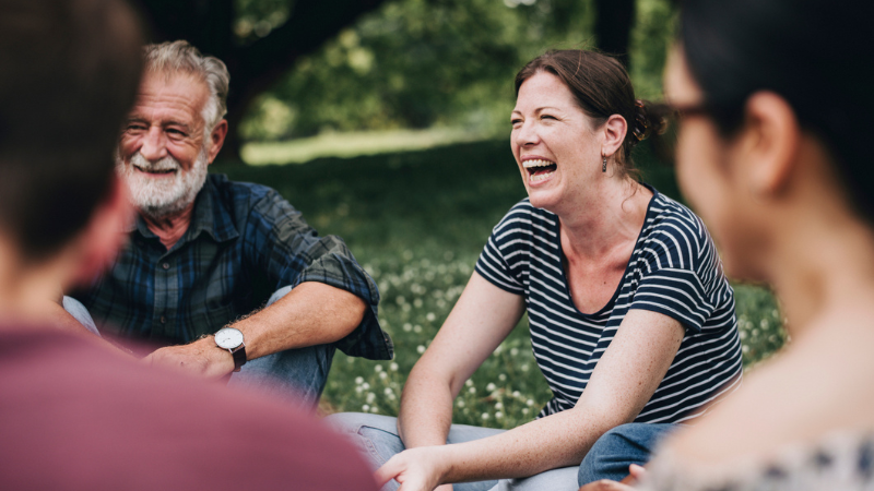 Groupe d'amis qui rient sur le gazon