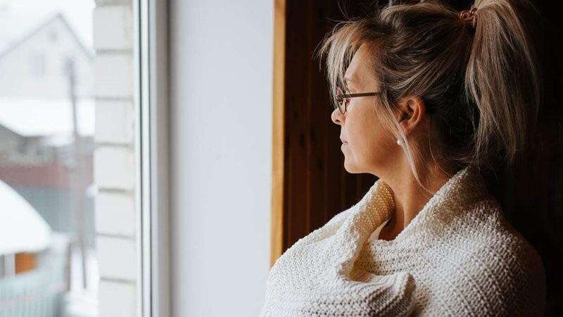 Femme déprimée qui regarde par la fenêtre